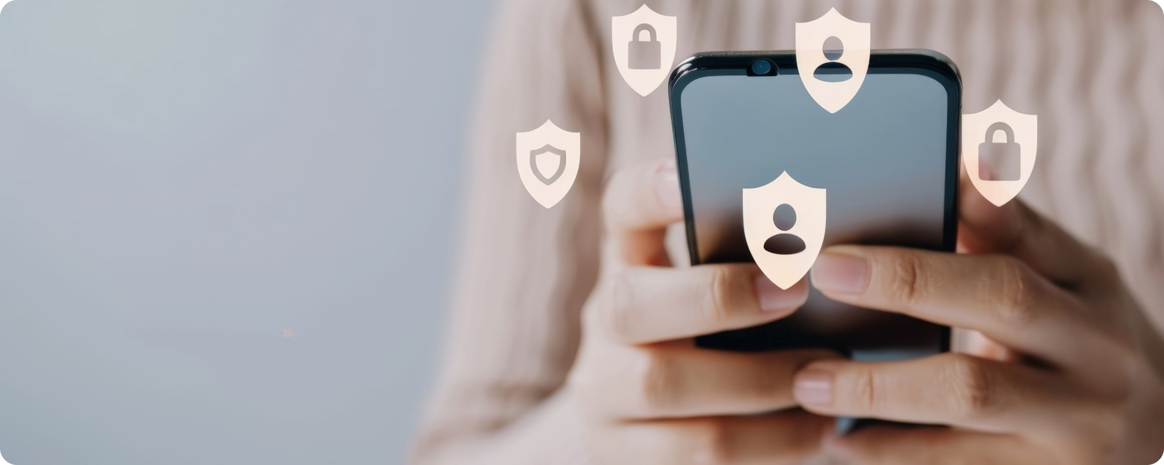 Frau mit beigem Strickpuller tippt auf Smartphone. Darüber sind Symbole für Cybersecurity und Datenschutz eingeblendet.