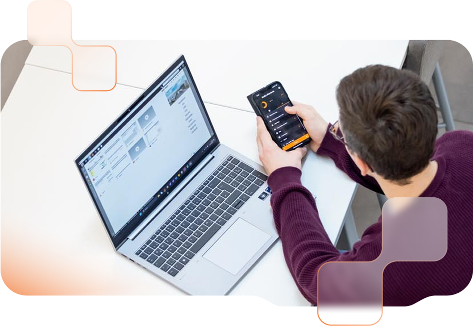 Mann benutzt Smartphone mit BMD Go App und Laptop mit BMD Software