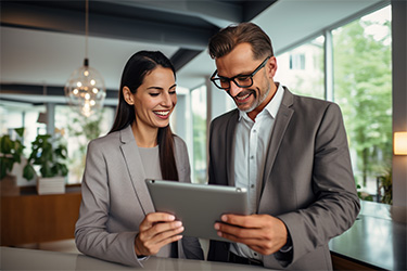Das Bild zeit eine Frau und einen Mann, die auf ein Tablet blicken. [© Radekcho - stock.adobe.com]
